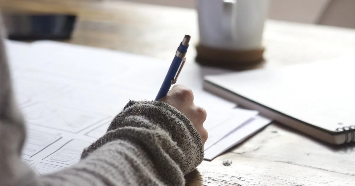 Person writing in a notebook at a desk, used for a Shopify glossary for beginners

---

# content