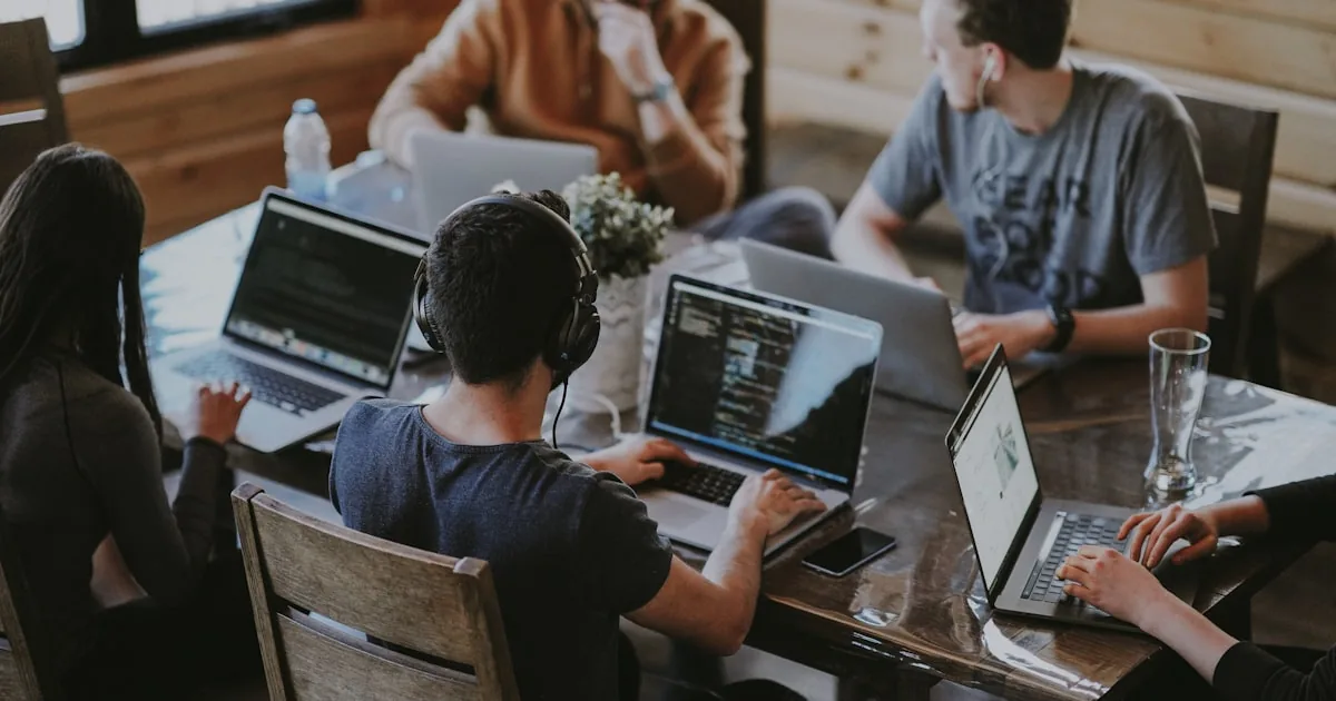 Two colleagues comparing notes at a laptop, used for a Shopify versus WooCommerce decision